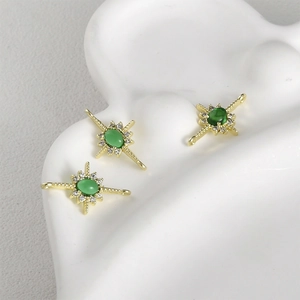Detailed view of 14k gold-plated starburst charms with green stones for DIY jewelry
