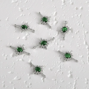 Macro view of starburst connectors with green stones and 14k gold-filled cubic zirconia