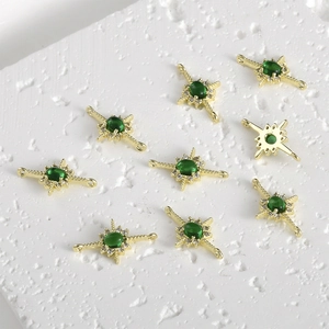 Macro view of 14k gold-plated starburst connector with green zircon and double loops