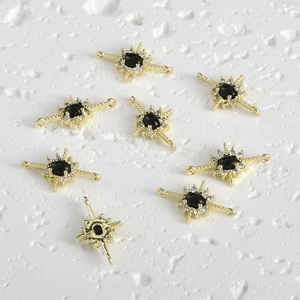 Macro detail of 14k gold plated starburst connector with black stone and white zircon