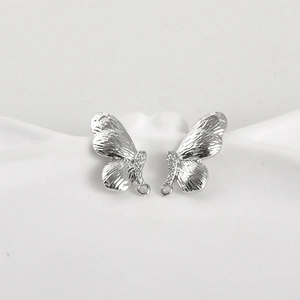 Gros plan de breloques papillon en argent avec texture martelée et zircons blancs