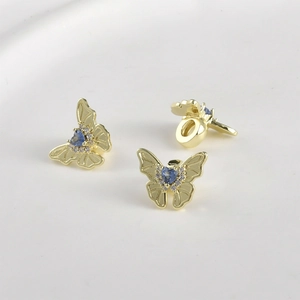 Macro detail of 14k gold plated butterfly charm with blue heart zircon for DIY jewelry