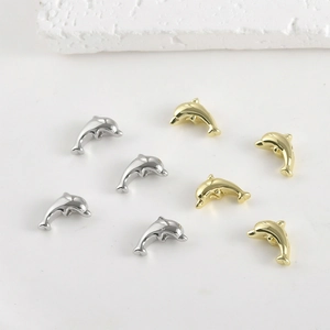 Macro detail of 14k gold-plated dolphin charms for DIY jewelry making and crafts