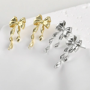 Detailed view of 14k gold-plated and silver bow pendants with spiral drop for DIY jewelry