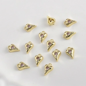 Gros plan de breloques cœurs plaquées or 14 carats avec zircon rose et cristaux blancs