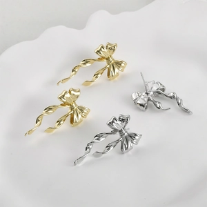 Polished 14k gold plated long bow dangle earrings set in gold and silver finish