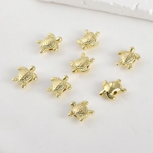 Macro view of 8 gold-plated turtle beads with detailed shells for DIY jewelry making