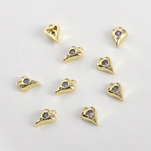 Gros plan de pendentifs en cœur plaqués or 14k avec cristaux violets et petits strass