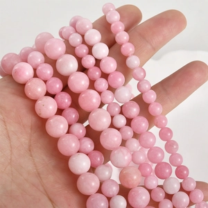 Natural peach pink jade 8mm round beads displayed in hand for jewelry DIY making