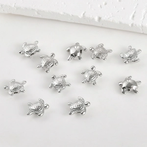 Macro detail of polished silver sea turtle beads for DIY jewelry making and bracelets
