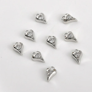 Détail de pendentifs en forme de cœur argentés avec petits zircons pour création de bijoux DIY