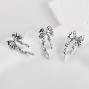 Polished silver bow-shaped metal pendants for DIY earrings making set of 3 on white plate