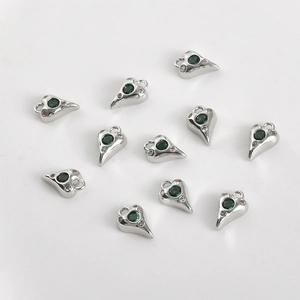 Vue détaillée de dix pendentifs cœur en argent avec pierre verte et petits cristaux