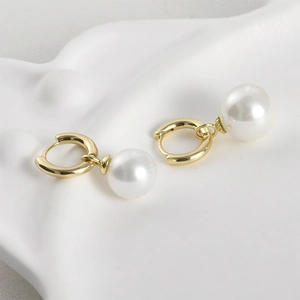 Detailed macro view of 14k gold-plated flower pearl earring dangles with smooth finish