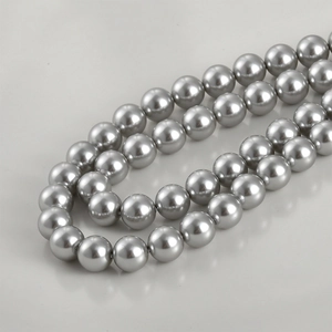 Macro detail of high-luster silver faux pearl beads with metallic finish for DIY jewelry