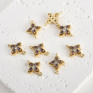 Detail of gold-plated four-leaf flower connectors with purple and white cubic zirconia