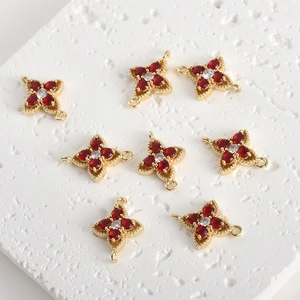 Detailed view of gold-plated clover jewelry connectors with red zircon stones for DIY