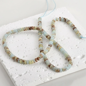 Macro detail of natural stone disc beads in blue and beige for DIY jewelry making
