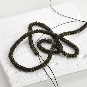 Macro detail of natural dark obsidian abacus beads showing smooth texture on stone surface