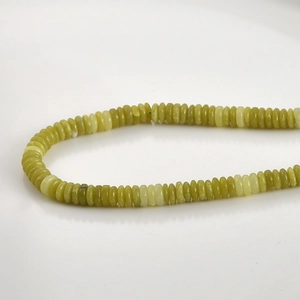 Macro shot of 2x6mm natural yellow-green jade abacus beads with smooth oily texture