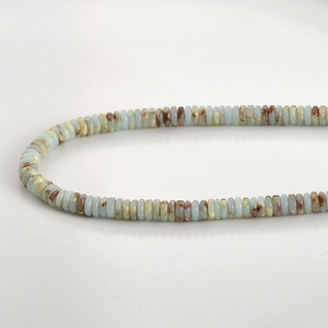 Macro detail of natural light blue jade rondelle beads with brown stone textures
