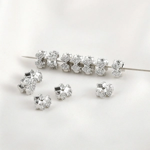 Macro detail of silver bow tie spacer beads with cubic zirconia for jewelry making
