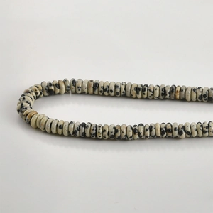 Close-up of natural Dalmatian Jasper flat disc beads for DIY jewelry making