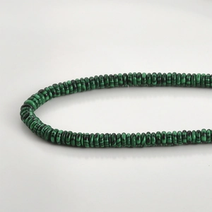 Macro shot of flat malachite beads showing natural green striped texture for DIY jewelry