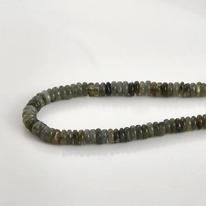 Macro detail of natural labradorite abacus beads with smooth grey-green mineral texture
