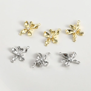 Macro shot of 14k gold and silver flower charms with zircon inlay for DIY jewelry