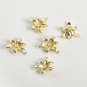 Detailed view of five 14k gold-plated flower pendants with central zircon stones for DIY