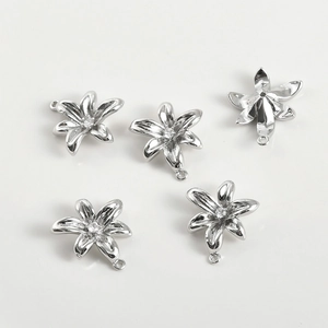 Macro shot of five silver floral pendants with central zircon for jewelry making
