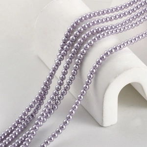 Macro detail of round light purple glass pearls with a glossy finish for DIY jewelry