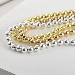 Macro view of polished gold and silver spherical beads for DIY jewelry making
