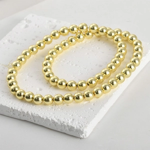 Detail of high-gloss gold plated round beads for DIY jewelry making and bracelets
