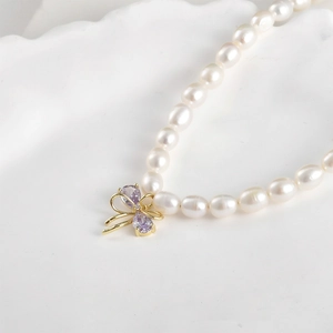14k gold plated pearl necklace with double layer bow pendant and purple gemstones