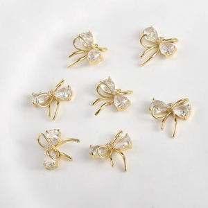 Detailed macro view of 14k gold plated bow charms with pear-cut zircon for jewelry DIY