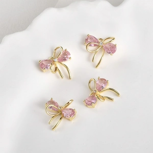 Close-up of pink zircon bow pendants with 14k gold plating for DIY jewelry making