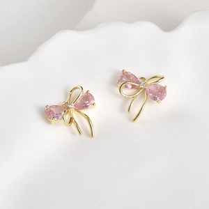 Macro detail of 14k gold plated bow pendant with pink pear-shaped zircon stones