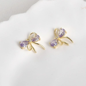 Close-up of 14k gold plated bow charms with purple zirconia stones for DIY jewelry making
