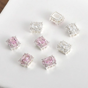 Macro shot of 14K silver plated rectangular charms with pink and clear cubic zirconia