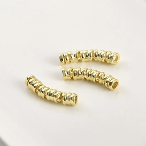 Detailed view of 14k gold-plated curved tube beads for DIY jewelry making and crafts
