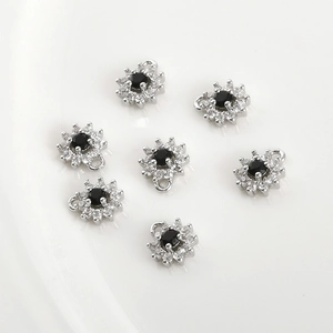 Detailed view of 7pcs four-leaf flower pendants with black zircon and silver plating