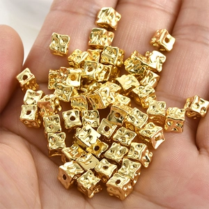 Detailed close-up of 14k gold plated square beads with hammer texture for DIY jewelry making