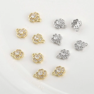 Macro detail of 14k gold plated flower pendants with zircon stones for DIY jewelry