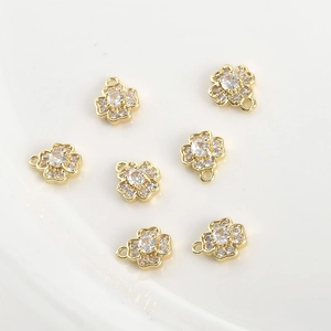 Detailed macro view of 14k gold-filled four-leaf clover charms with zircon stones