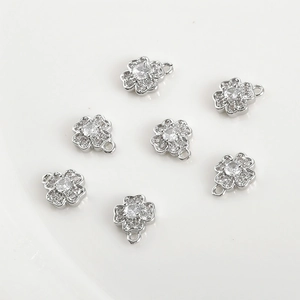 Macro shot of silver clover pendants with zircon stones and integrated hanging loops