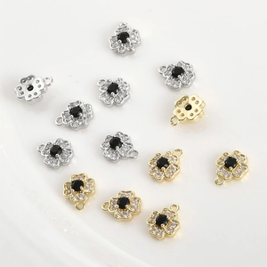 Detailed macro view of 14k gold plated four-leaf flower pendants with zircon stones