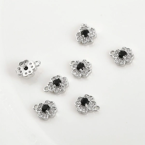 Detail view of 14k gold-filled flower pendants with black stone and white zircon stones