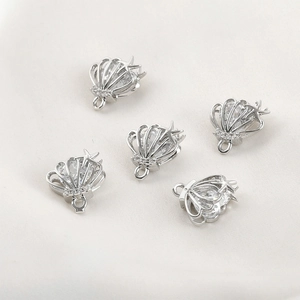 Detailed close-up of five silver seashell and starfish charms with cubic zirconia stones